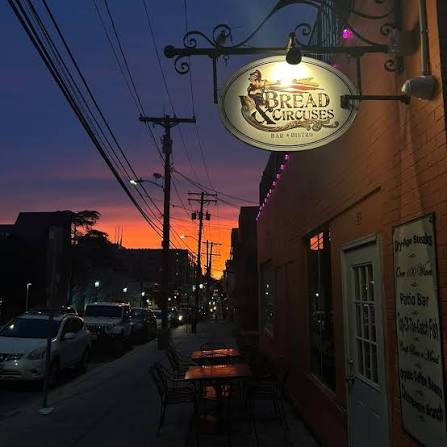 The Bread and Circuses sign on a Baltimore street at sunset